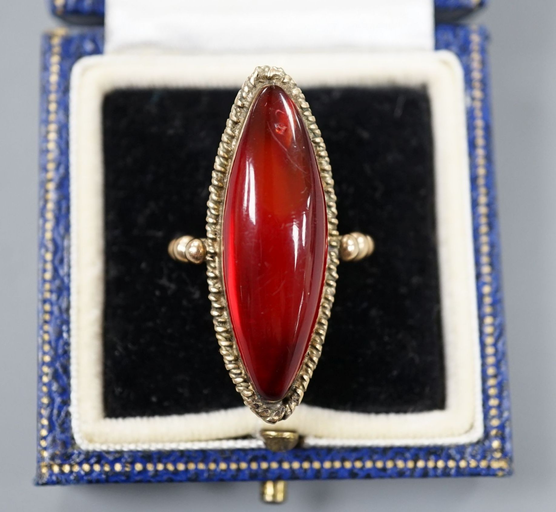 A large yellow metal and amber set marquise shaped dress ring, size N, gross weight 7.6 grams.